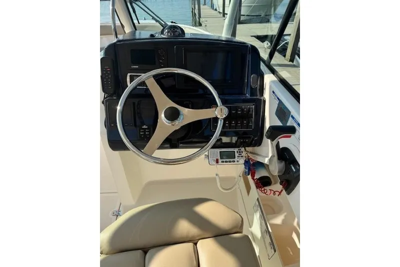 Slide: The Image of Helm of 2015 Pursuit DC 265 Dual Console boat with steering wheel and controls. - 3