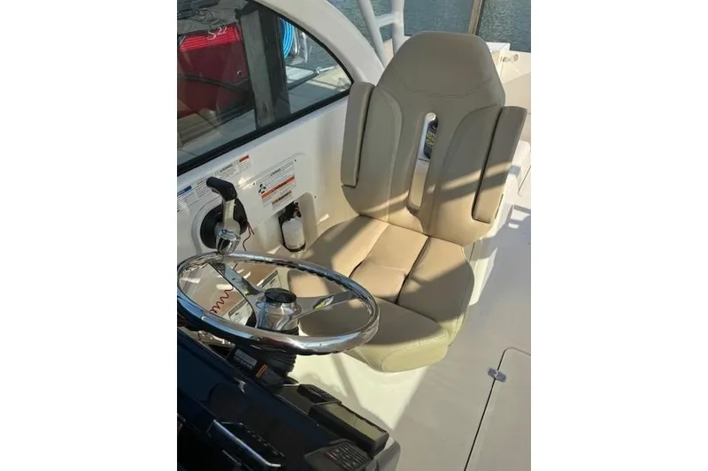 Slide: The Image of 2015 Pursuit DC 265 Dual Console boat helm with beige captain's seat and steering wheel. - 4