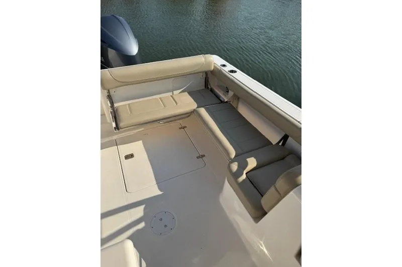 Slide: The Image of 2015 Pursuit DC 265 Dual Console boat interior with beige seating and water view. - 6