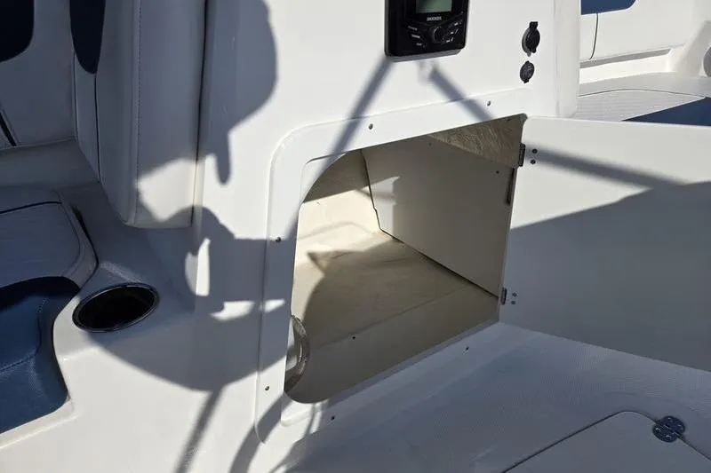 Slide: The Image of 2024 Tahoe 2150 boat interior storage compartment with open door and seating area. - 12