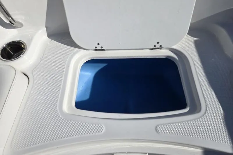 Slide: The Image of 2024 Tahoe 2150 boat storage compartment with open lid, showcasing interior space. - 14