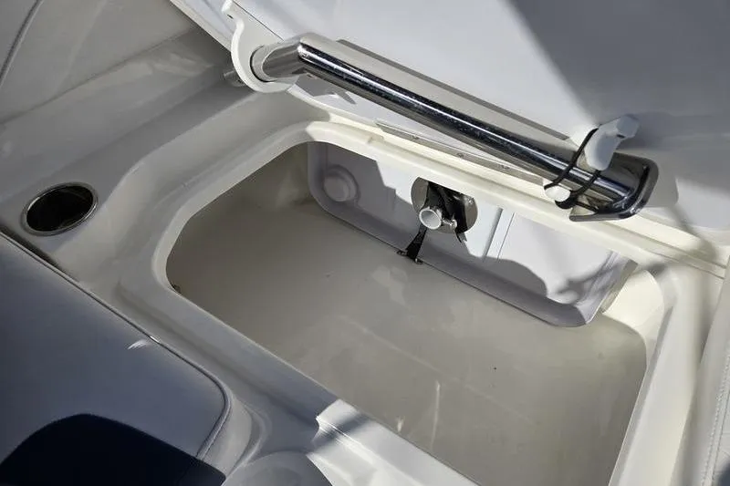 Slide: The Image of Open storage compartment in 2024 Tahoe 2150 boat, featuring sleek design and chrome handle. - 19