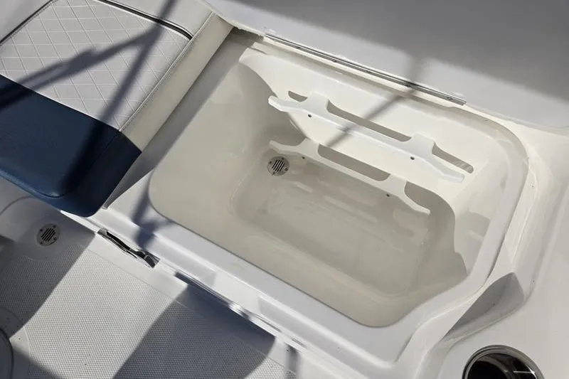 Slide: The Image of 2024 Tahoe 2150 boat storage compartment with cushioned seating and drainage. - 20