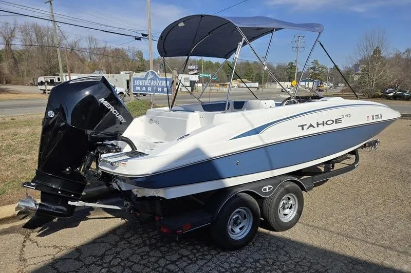 Slide: The Image of 2024 Tahoe 2150 boat on trailer with Mercury engine, parked outdoors. - 4