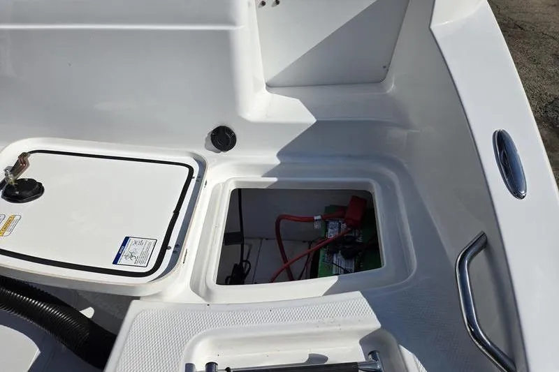 Slide: The Image of 2024 Tahoe 2150 boat storage compartments with visible battery and wiring. - 8