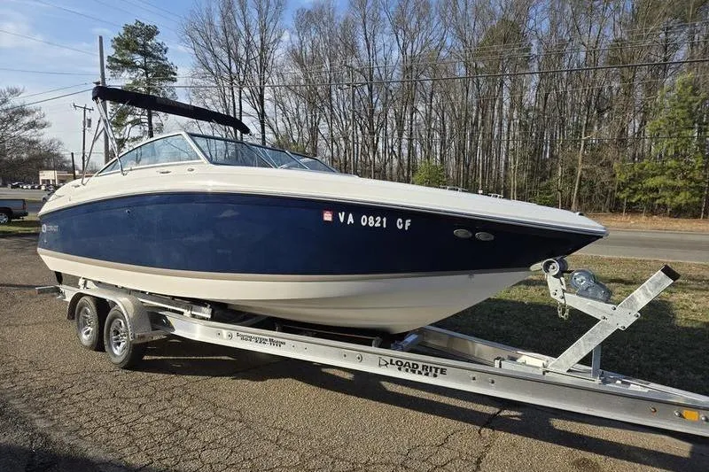 Slide: The Image of 2006 Cobalt 232 boat on trailer, parked outdoors near trees. - 1