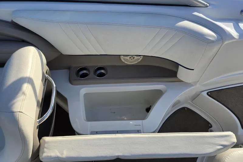 Slide: The Image of 2006 Cobalt 232 boat interior with white seating and built-in cup holders. - 10