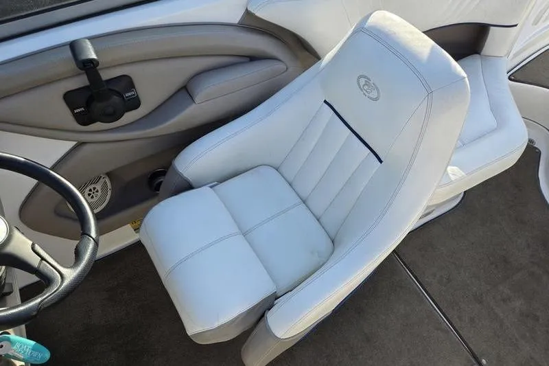 Slide: The Image of 2006 Cobalt 232 boat interior with white captain's chair and steering wheel. - 14