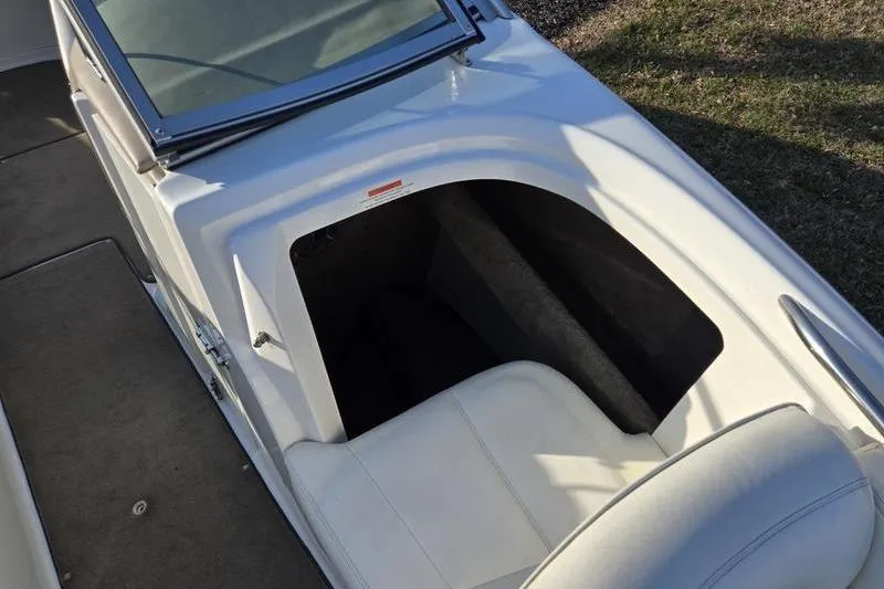 Slide: The Image of 2006 Cobalt 232 boat interior with white seating and storage compartment. - 15