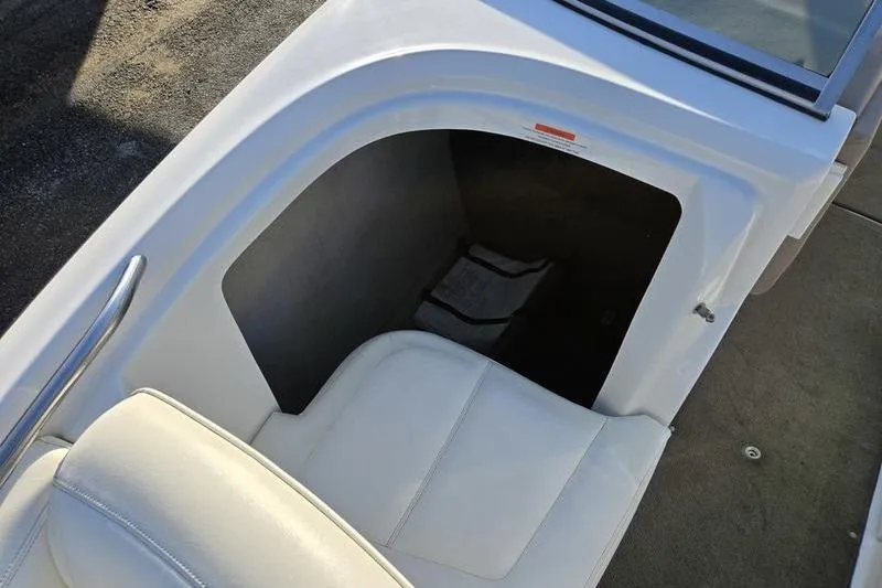 Slide: The Image of 2006 Cobalt 232 boat interior with white seating and storage compartment. - 17