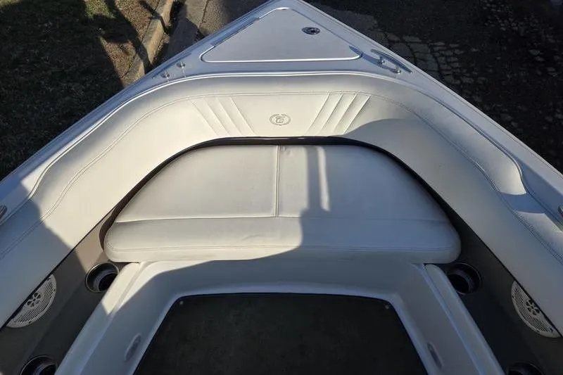 Slide: The Image of 2006 Cobalt 232 boat interior with white cushioned seating and cup holders. - 20