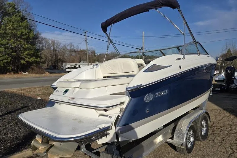 Slide: The Image of 2006 Cobalt 232 boat on trailer, blue and white design, parked outdoors. - 3