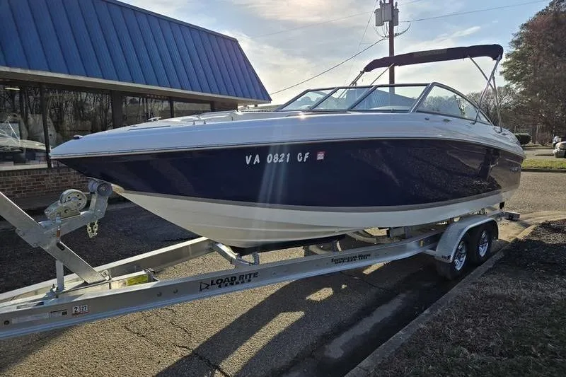 Slide: The Image of 2006 Cobalt 232 boat on trailer, parked outdoors near a building. - 5