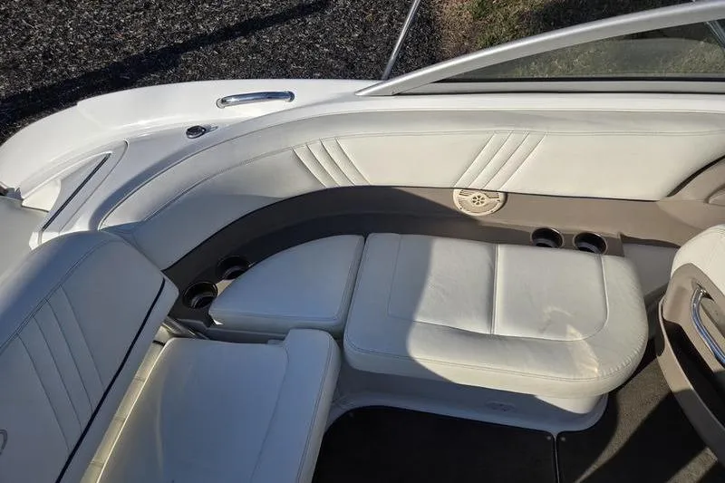 Slide: The Image of 2006 Cobalt 232 boat interior with white leather seating and cup holders. - 6