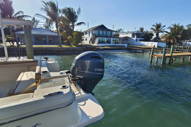 Slide: The Image of 2020 Scout 215 XSF boat with Yamaha engine docked near waterfront homes. - 17