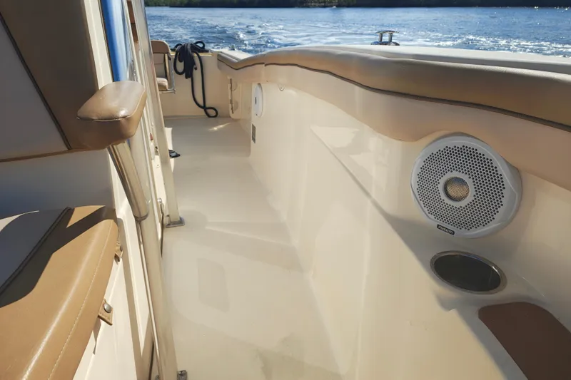 Slide: The Image of 2020 Scout 215 XSF boat interior with speaker and cup holder, cruising on water. - 5