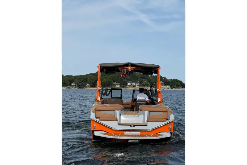 Slide: The Image of 2022 Nautique Super Air Nautique G25 boat on a lake, rear view. - 3