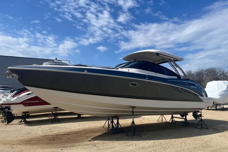 Slide: The Image of 2017 Formula 350 Crossover Bowrider boat on stands under a clear blue sky. - 3