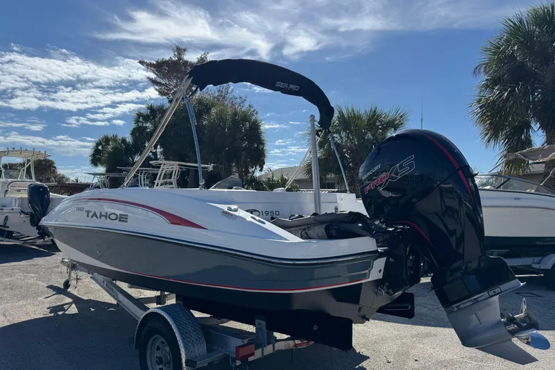 Slide: The Image of 2023 Tahoe 1950 boat on trailer with Mercury Pro XS engine, parked outdoors. - 6