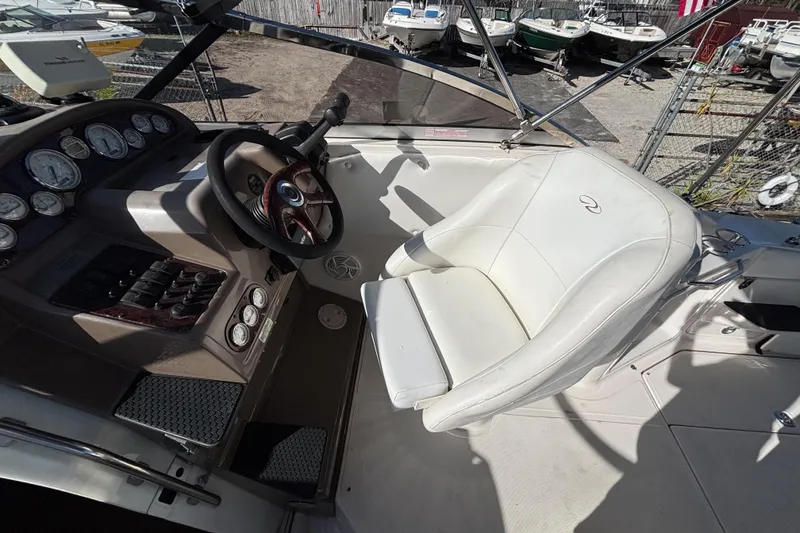 Slide: The Image of 2005 Regal Commodore 2765 boat cockpit with steering wheel and white captain's chair. - 21