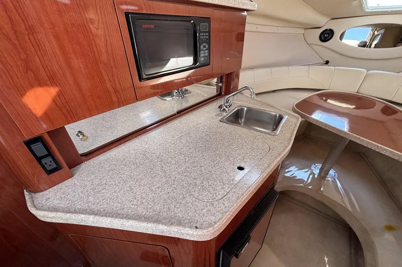 Slide: The Image of 2005 Regal Commodore 2765 boat interior with kitchenette, sink, and seating area. - 30