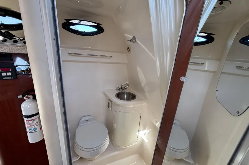 Slide: The Image of 2005 Regal Commodore 2765 boat bathroom with toilet, sink, and porthole window. - 35