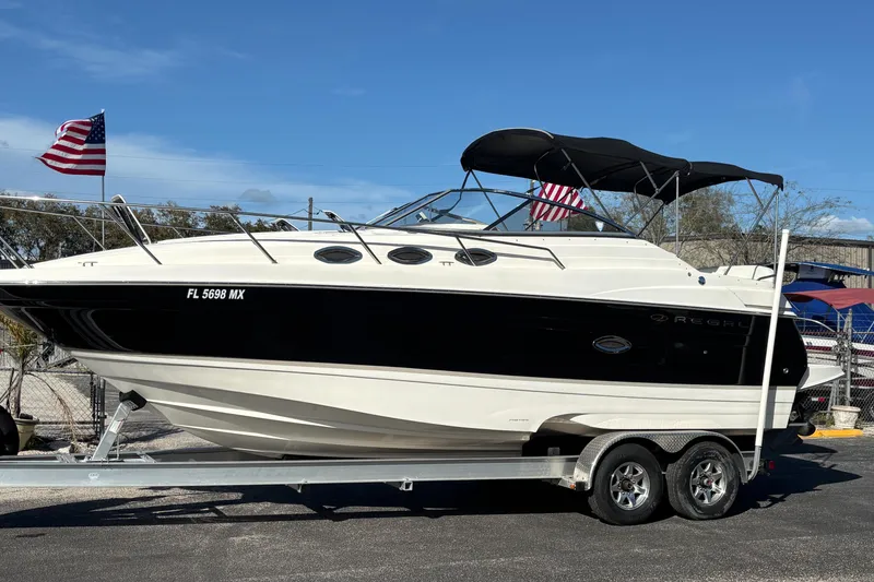 Slide: The Image of 2005 Regal Commodore 2765 boat on trailer, American flag in background, sunny day. - 7