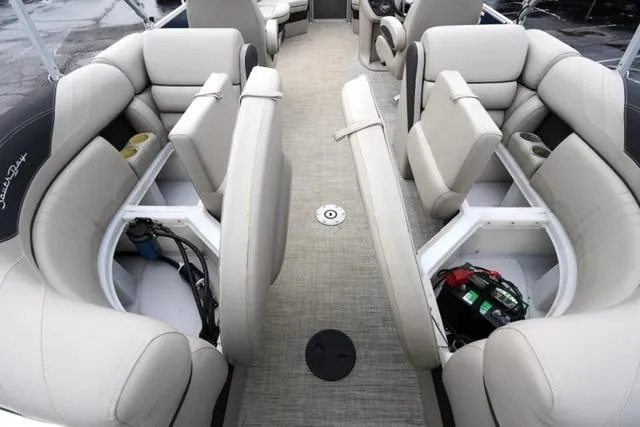 Slide: The Image of 2022 South Bay 222RS LE pontoon boat interior with beige seating and storage compartments. - 15