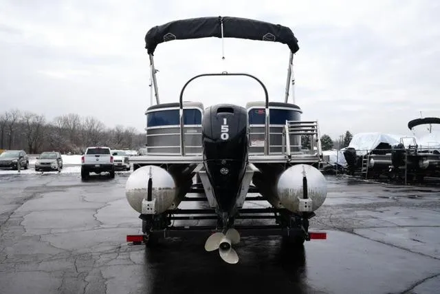 Slide: The Image of 2022 South Bay 222RS LE pontoon boat with 150 HP motor, parked outdoors. - 6