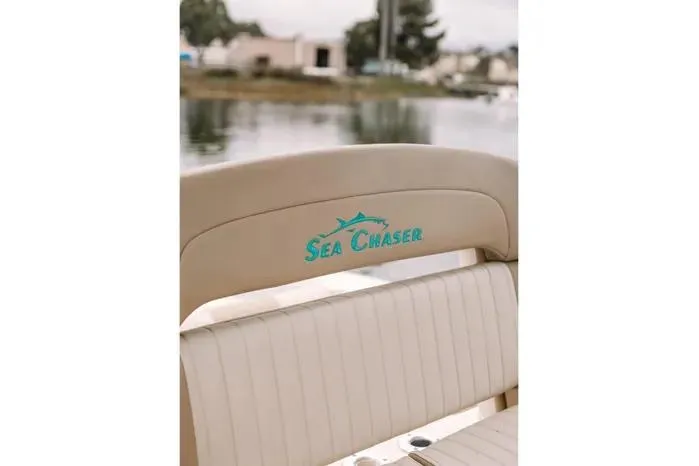 Slide: The Image of 2019 Carolina Skiff 27' Center Console boat with "Sea Chaser" logo on beige seating. - 5