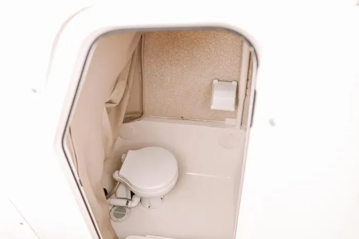 Slide: The Image of 2019 Carolina Skiff 27' Center Console boat interior with compact marine toilet. - 9