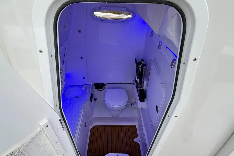 Slide: The Image of 2026 Sea Hunt Ultra 285 SE boat bathroom with modern amenities and blue ambient lighting. - 13