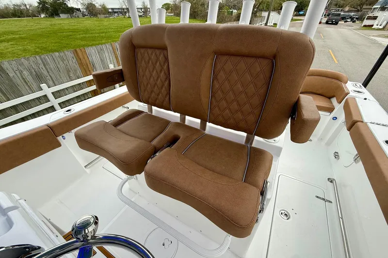 Slide: The Image of 2026 Sea Hunt Ultra 285 SE boat with brown cushioned seating and rod holders. - 9