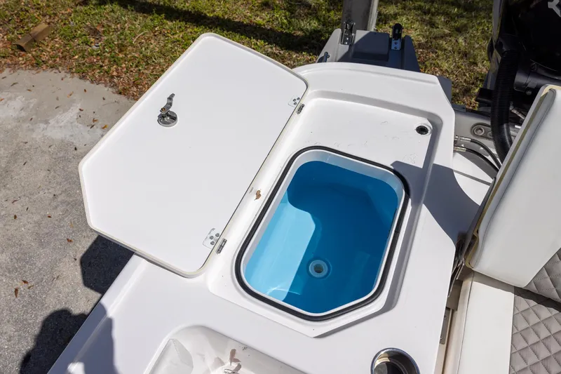 Slide: The Image of Open storage compartment on 2022 Caymas 28 HB Twin boat, featuring a blue interior. - 10