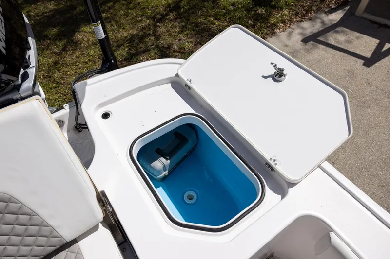 Slide: The Image of Open storage compartment on 2022 Caymas 28 HB Twin boat, featuring blue interior. - 11