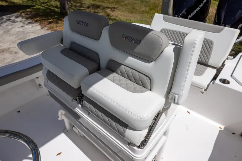 Slide: The Image of Luxury seating on 2022 Caymas 28 HB Twin boat, featuring cushioned armrests and quilted upholstery. - 16