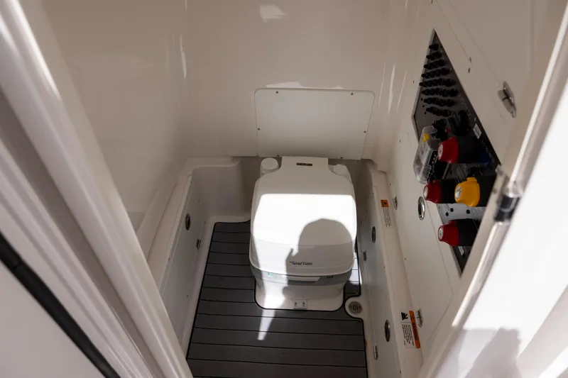 Slide: The Image of 2022 Caymas 28 HB Twin boat interior with compact marine toilet and control panel. - 18