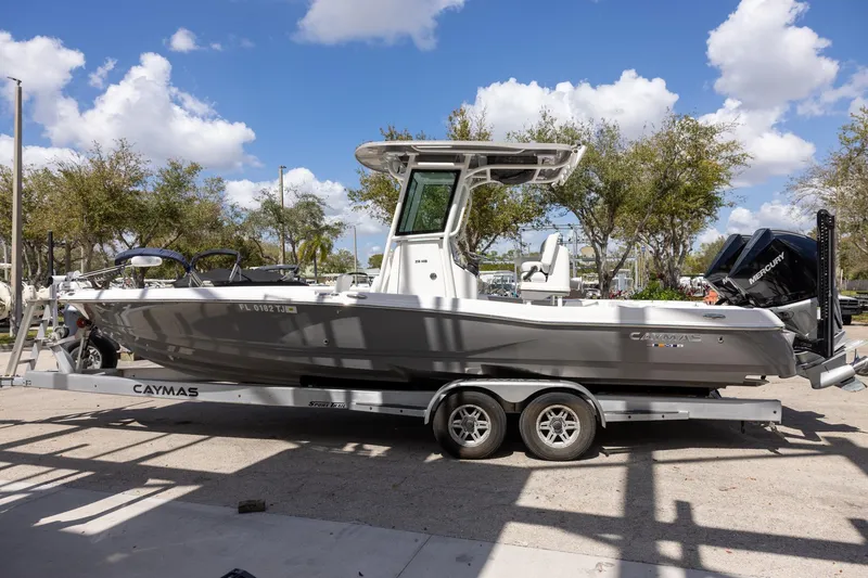 Slide: The Image of 2022 Caymas 28 HB Twin boat on trailer, parked outdoors under blue sky. - 3