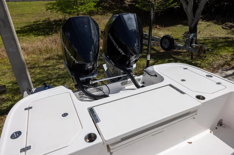Slide: The Image of 2022 Caymas 28 HB Twin boat with dual Mercury outboard engines, parked on grass. - 8