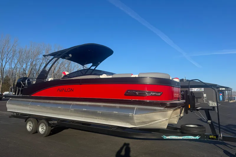Slide: The Image of 2025 Avalon Catalina Cruise Rear Bench Windshield pontoon boat on trailer, sunny day. - 1