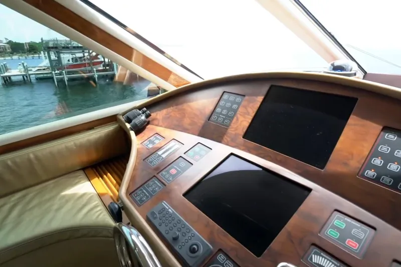 Slide: The Image of 1987 Magnum 70 Convertible yacht dashboard with control panels and scenic water view. - 15