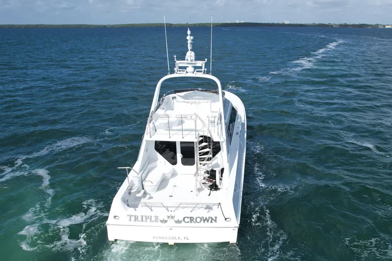 Slide: The Image of 1987 Magnum 70 Convertible yacht cruising on open water, rear view. - 3