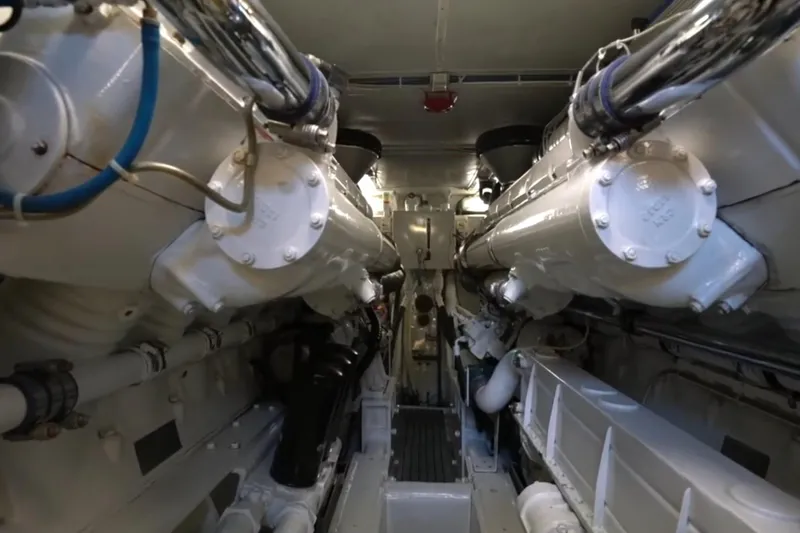 Slide: The Image of Engine room of a 1987 Magnum 70 Convertible yacht, showcasing dual engines and piping. - 30