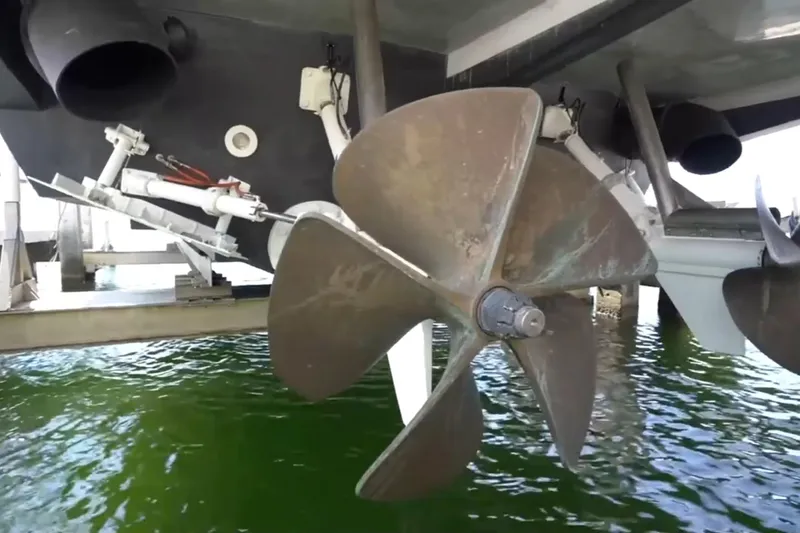 Slide: The Image of Close-up of a 1987 Magnum 70 Convertible boat propeller above green water. - 31