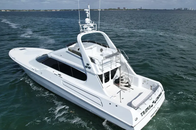 Slide: The Image of 1987 Magnum 70 Convertible yacht cruising on open water, rear view. - 38