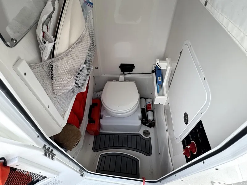 Slide: The Image of 2022 Sea Hunt Ultra 275 SE boat interior with toilet and storage area. - 16