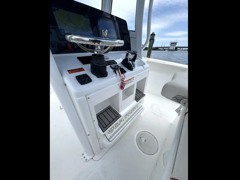 Slide: The Image of 2022 Sea Hunt Ultra 275 SE boat console with steering wheel and controls. - 27
