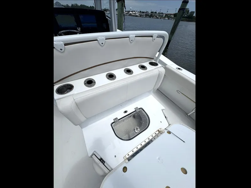Slide: The Image of 2022 Sea Hunt Ultra 275 SE boat interior with cup holders and storage compartment. - 3
