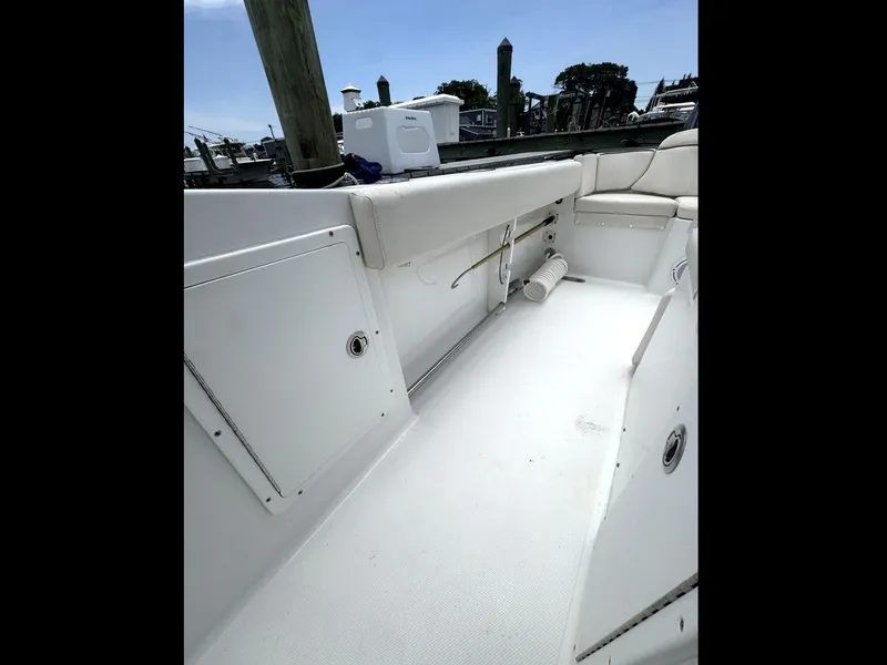 Slide: The Image of 2022 Sea Hunt Ultra 275 SE boat interior with white seating and storage compartments. - 31