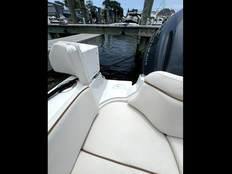 Slide: The Image of 2022 Sea Hunt Ultra 275 SE boat interior with white seating at dock. - 37